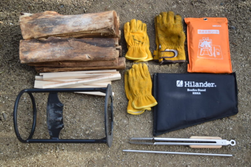 ワットノットワンタッチバケットに収納している道具一式を映した画像。薪やマキワリキ、焚火台が並んでいる。